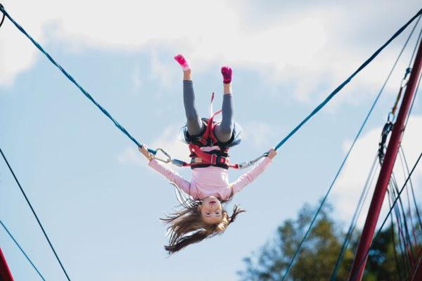 a girl doing flips on bungie cords